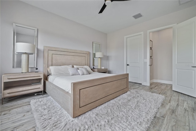 bedroom featuring baseboards, visible vents, wood finished floors, and a ceiling fan