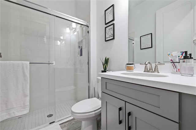 full bathroom with toilet, vanity, and a stall shower
