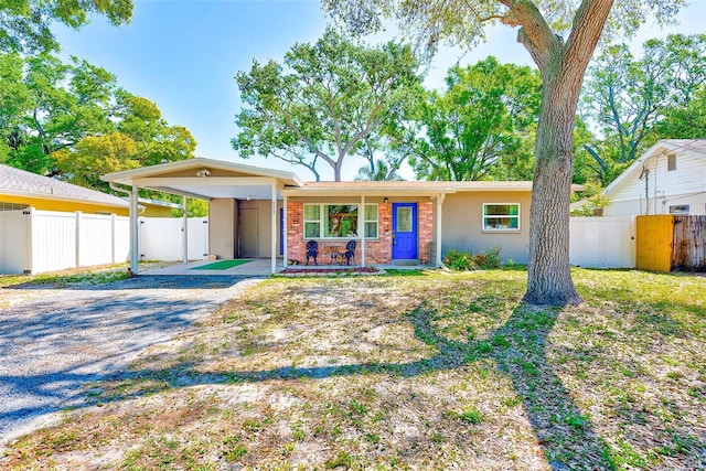700 16th St NW, Largo, FL 33770 - ranch-style house with a carport, gravel driveway, fence, and a gate