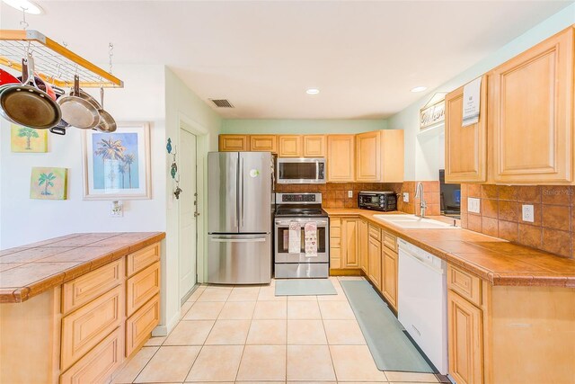 700 16th St NW, Largo, FL 33770 - kitchen with light brown cabinetry, visible vents, appliances with stainless steel finishes, and a sink