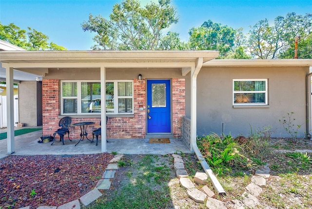 700 16th St NW, Largo, FL 33770 - view of exterior entry with covered porch, brick siding, and stucco siding