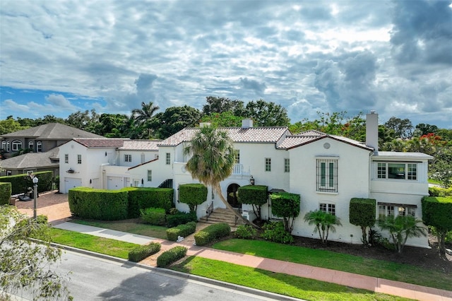 1102 Palm View Ave, Belleair, FL 33756 - mediterranean / spanish home with a chimney, a residential view, stucco siding, and a tile roof