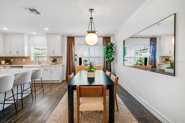 dining space with dark wood finished floors, ornamental molding, visible vents, recessed lighting, and baseboards