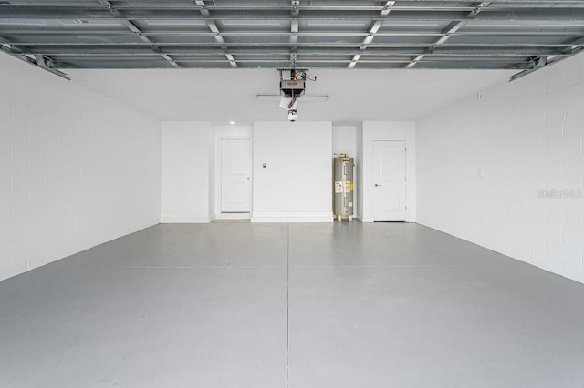 garage featuring a garage door opener, electric water heater, and concrete block wall