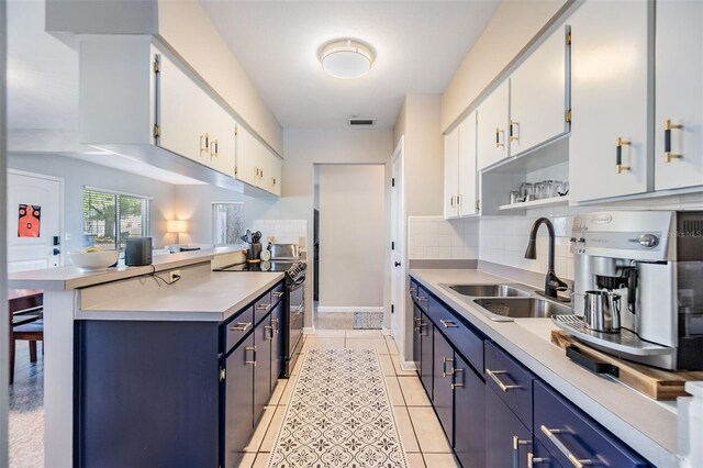 2808 W Lake Ave, Tampa, FL 33607 - kitchen featuring electric range, blue cabinets, light countertops, a sink, and backsplash