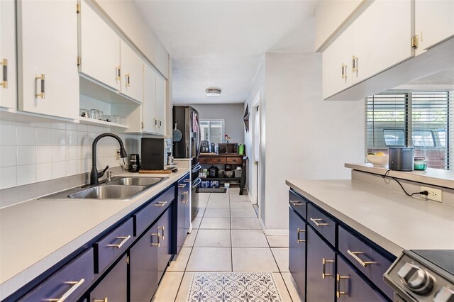 2808 W Lake Ave, Tampa, FL 33607 - kitchen featuring light countertops, tasteful backsplash, a sink, and white cabinetry