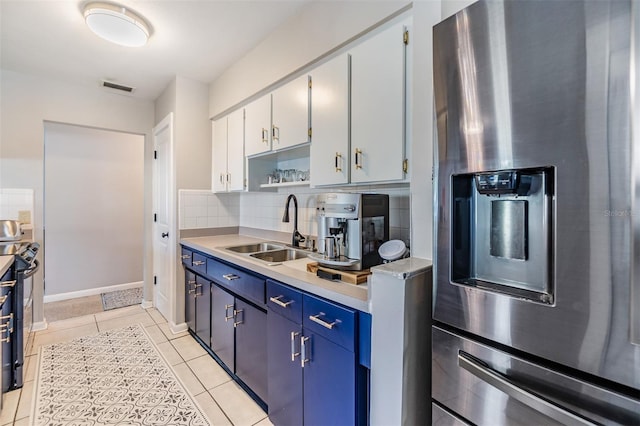 2808 W Lake Ave, Tampa, FL 33607 - kitchen with stainless steel fridge with ice dispenser, tasteful backsplash, light tile patterned floors, light countertops, and a sink