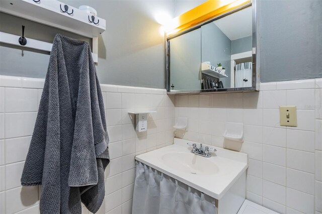 2808 W Lake Ave, Tampa, FL 33607 - bathroom with vanity, a wainscoted wall, and tile walls