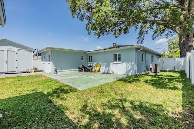 2808 W Lake Ave, Tampa, FL 33607 - rear view of property featuring a storage shed, a fenced backyard, stucco siding, an outdoor structure, and a patio