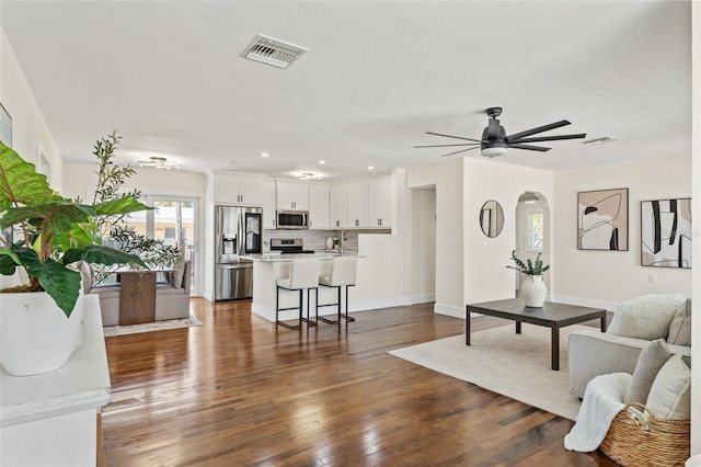 601 Boca Ciega Isle Dr, St Pete Beach, FL 33706 - living area with arched walkways, visible vents, a ceiling fan, and dark wood finished floors