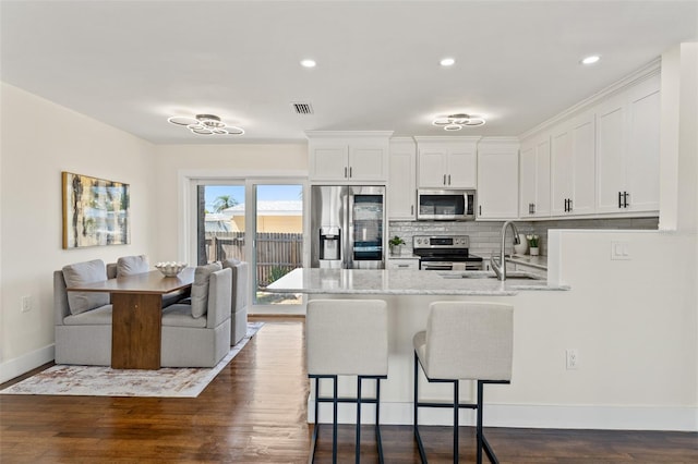 601 Boca Ciega Isle Dr, St Pete Beach, FL 33706 - kitchen with decorative backsplash, visible vents, a peninsula, appliances with stainless steel finishes, and a sink