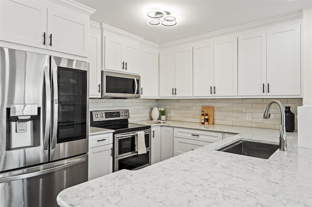 601 Boca Ciega Isle Dr, St Pete Beach, FL 33706 - kitchen with light stone countertops, stainless steel appliances, tasteful backsplash, white cabinetry, and a sink