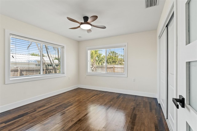 601 Boca Ciega Isle Dr, St Pete Beach, FL 33706 - unfurnished bedroom featuring multiple windows, visible vents, baseboards, and dark wood-type flooring