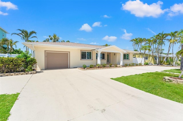 601 Boca Ciega Isle Dr, St Pete Beach, FL 33706 - ranch-style home featuring driveway, a front yard, stucco siding, fence, and an attached garage