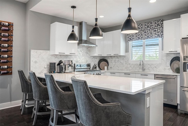 2511 N Grady Ave Unit 82, Tampa, FL 33607 - kitchen with appliances with stainless steel finishes, wall chimney exhaust hood, dark wood-type flooring, a sink, and a peninsula