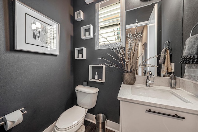 2511 N Grady Ave Unit 82, Tampa, FL 33607 - half bath featuring vanity, toilet, wood finished floors, baseboards, and a textured wall