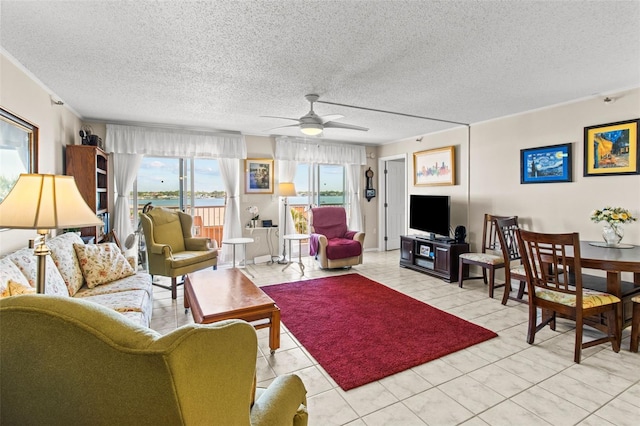 living area featuring light tile patterned flooring, ceiling fan, and a textured ceiling
