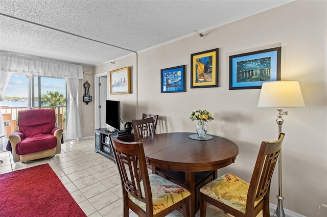 dining space featuring light tile patterned floors, crown molding, baseboards, and a textured ceiling