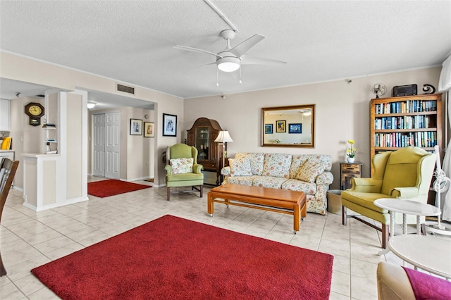 living area featuring a ceiling fan, light tile patterned flooring, a textured ceiling, and visible vents