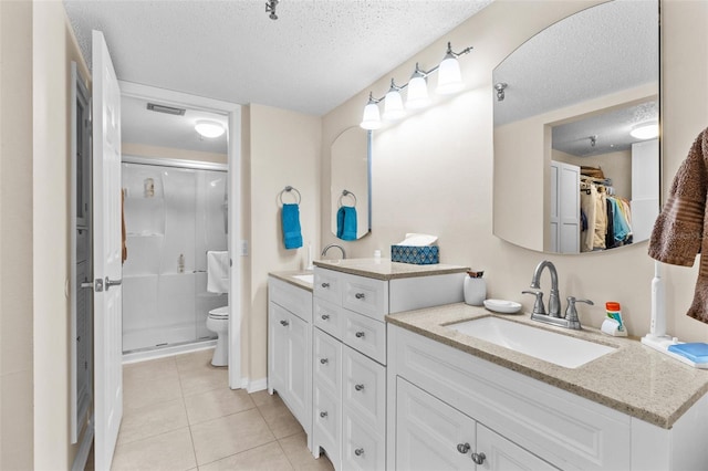 full bath with a shower stall, a textured ceiling, tile patterned floors, a sink, and double vanity