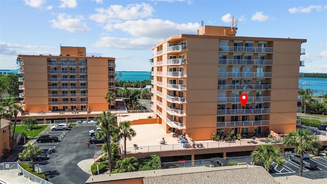 view of property featuring uncovered parking and a water view