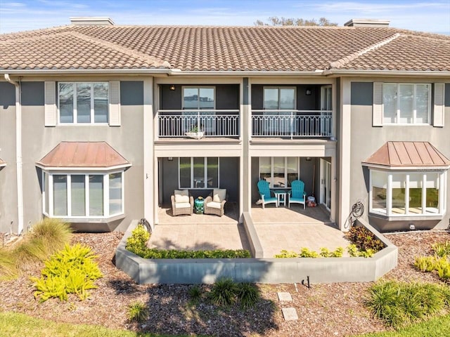 2087 Edgewater Dr Unit C, Clearwater, FL 33755 - rear view of house featuring a balcony, stucco siding, an outdoor hangout area, a patio area, and a tiled roof