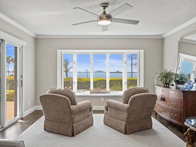 2087 Edgewater Dr Unit C, Clearwater, FL 33755 - sitting room featuring wood finished floors, plenty of natural light, crown molding, a ceiling fan, and a water view