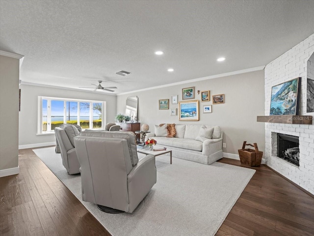 2087 Edgewater Dr Unit C, Clearwater, FL 33755 - living room featuring ornamental molding, a textured ceiling, a ceiling fan, dark wood-style floors, and a brick fireplace