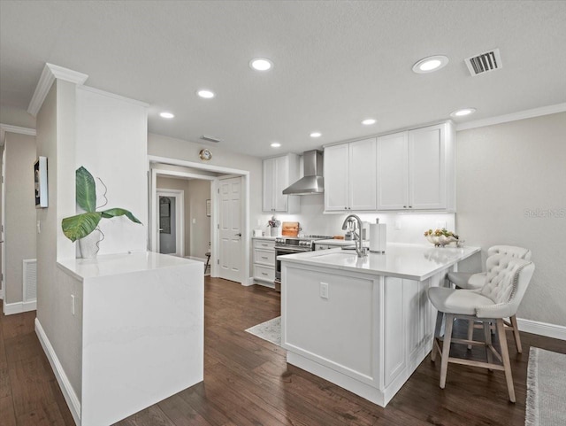 2087 Edgewater Dr Unit C, Clearwater, FL 33755 - kitchen with wall chimney exhaust hood, electric stove, ornamental molding, a peninsula, and white cabinets