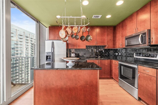 777 N Ashley Dr Unit 2807, Tampa, FL 33602 - kitchen with decorative backsplash, light wood-style flooring, appliances with stainless steel finishes, a sink, and a center island