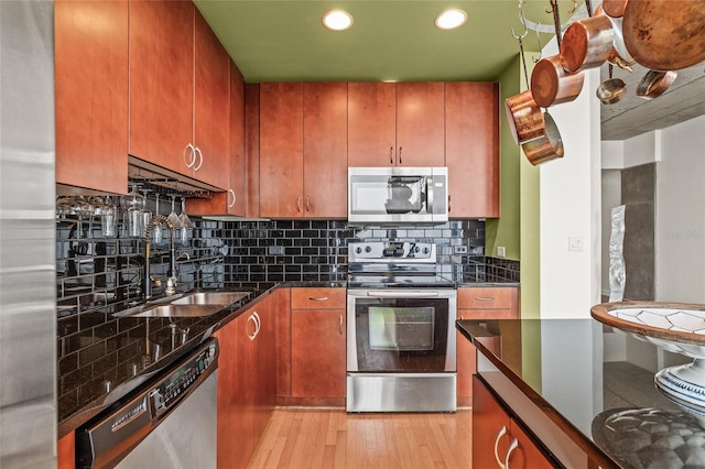 777 N Ashley Dr Unit 2807, Tampa, FL 33602 - kitchen featuring a sink, backsplash, appliances with stainless steel finishes, brown cabinetry, and light wood-style floors