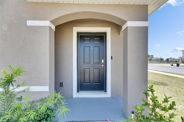 entrance to property with stucco siding