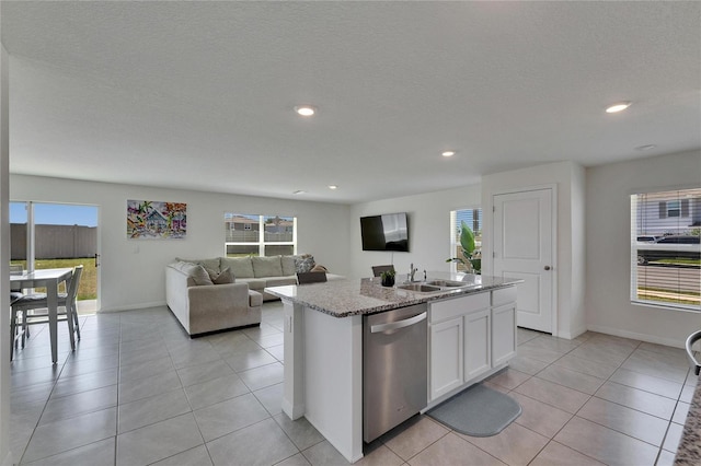 kitchen featuring light tile patterned floors, white cabinets, dishwasher, a sink, and light stone countertops