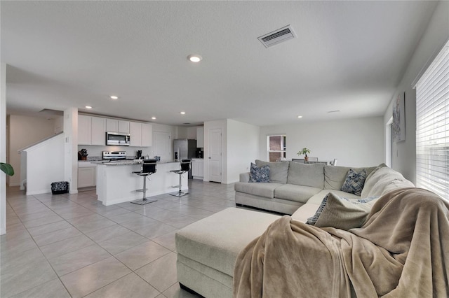 living area with visible vents, baseboards, recessed lighting, and light tile patterned floors
