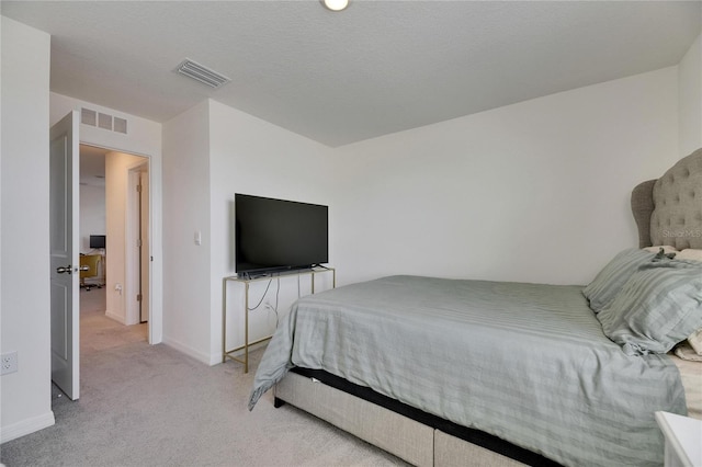 carpeted bedroom featuring baseboards and visible vents