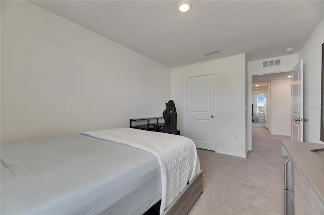 bedroom featuring a textured ceiling, light colored carpet, baseboards, and visible vents