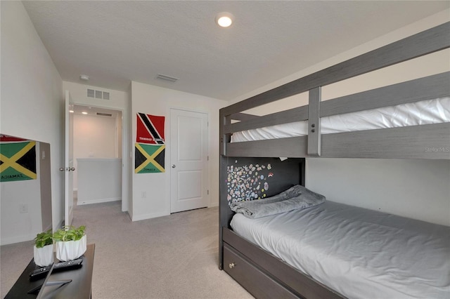 bedroom featuring a textured ceiling, light colored carpet, baseboards, and visible vents