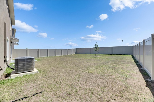 view of yard with central air condition unit and a fenced backyard