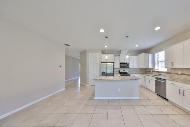kitchen with a center island, tasteful backsplash, a sink, stainless steel appliances, and white cabinetry