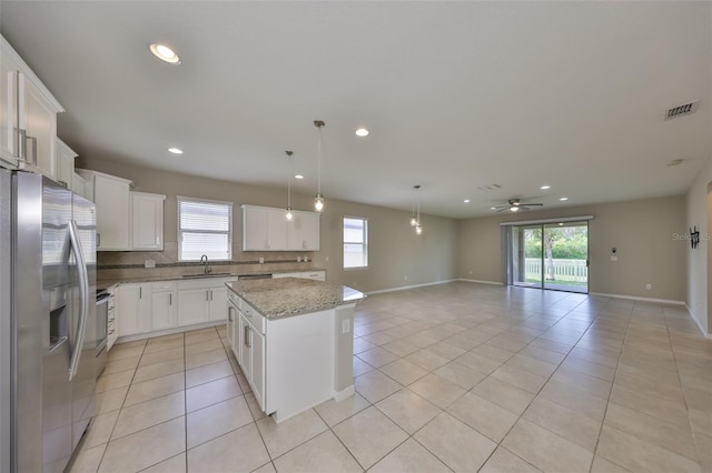 kitchen with stainless steel appliances, visible vents, light tile patterned floors, and a center island