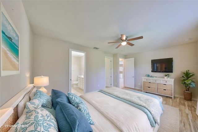 bedroom with visible vents, light wood-style floors, ensuite bathroom, baseboards, and ceiling fan
