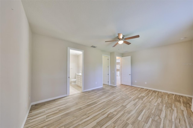empty room with light wood-style floors, baseboards, ceiling fan, and visible vents