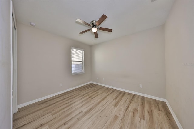 unfurnished room with baseboards, a ceiling fan, and light wood-style flooring