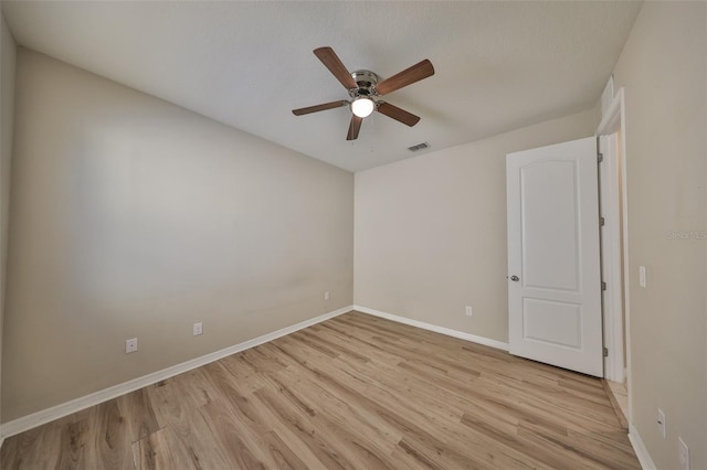 empty room featuring light wood-type flooring, baseboards, ceiling fan, and visible vents