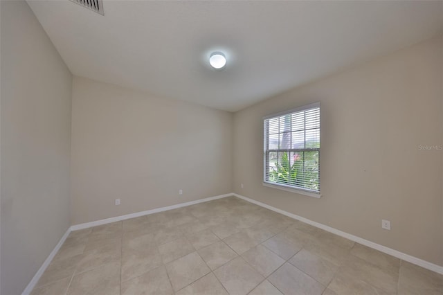 spare room featuring light tile patterned flooring, baseboards, and visible vents