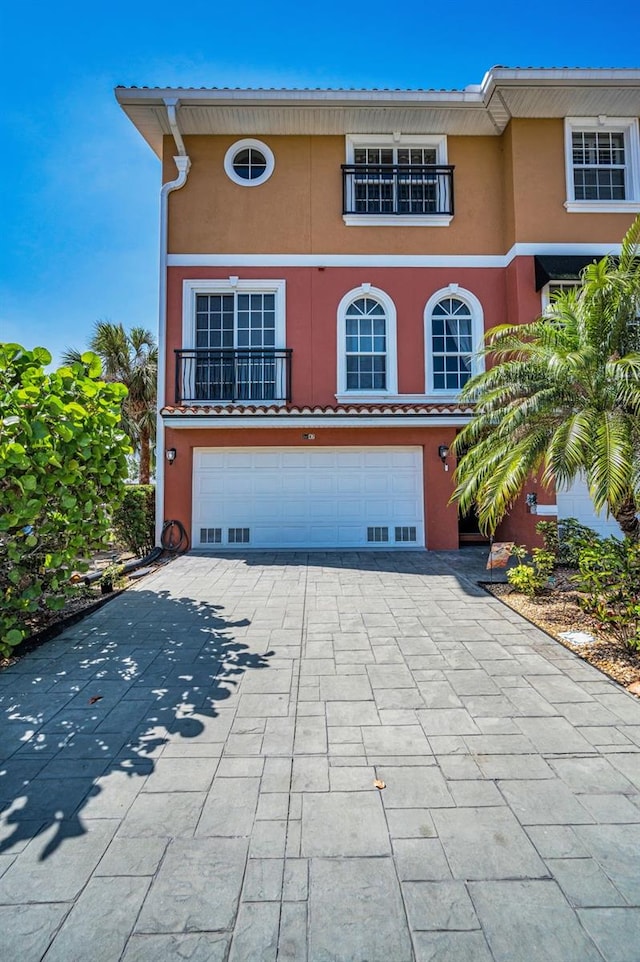 47 W Morgan St, Tarpon Springs, FL 34689 - view of front of home with a garage, a balcony, stucco siding, and driveway
