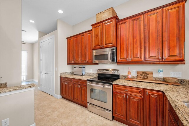 47 W Morgan St, Tarpon Springs, FL 34689 - kitchen featuring appliances with stainless steel finishes, light stone countertops, and light tile patterned flooring