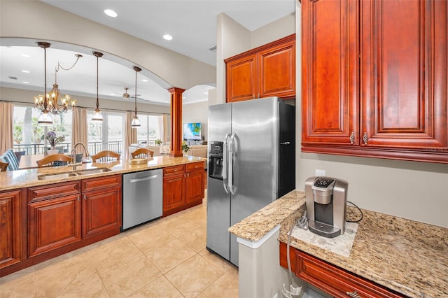 47 W Morgan St, Tarpon Springs, FL 34689 - kitchen with decorative columns, a sink, light stone counters, reddish brown cabinets, and stainless steel appliances