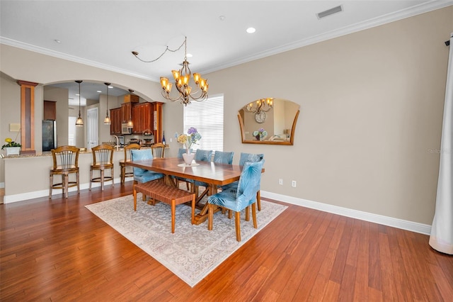 47 W Morgan St, Tarpon Springs, FL 34689 - dining space featuring dark wood-style flooring, a notable chandelier, arched walkways, baseboards, and visible vents