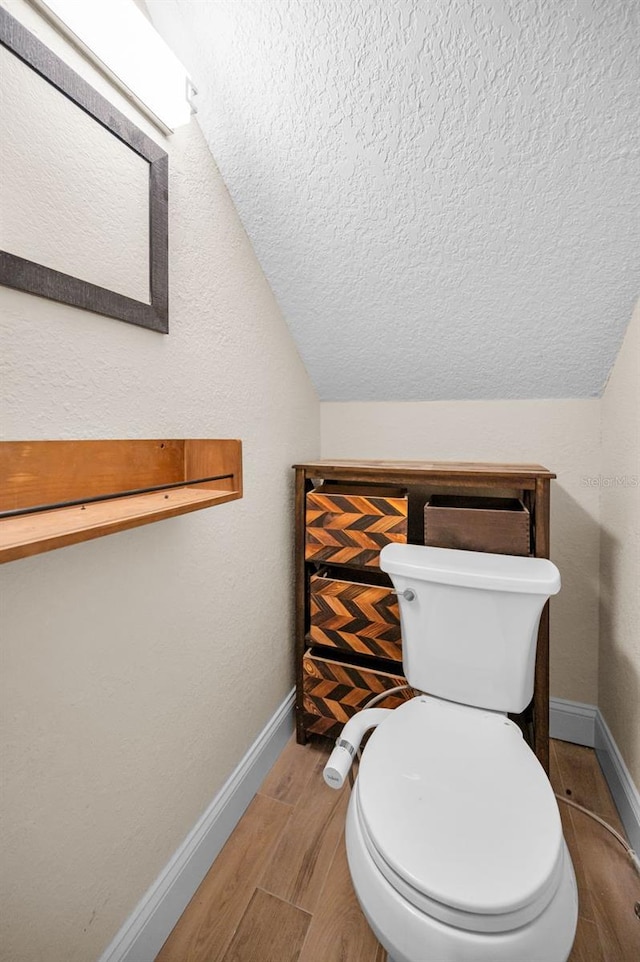 47 W Morgan St, Tarpon Springs, FL 34689 - bathroom featuring baseboards, vaulted ceiling, toilet, and a textured ceiling
